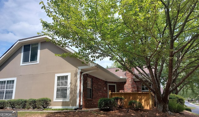 view of home's exterior with stucco siding and brick siding