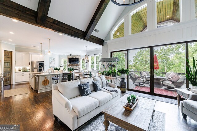 living room featuring high vaulted ceiling, dark hardwood / wood-style flooring, beam ceiling, and a notable chandelier