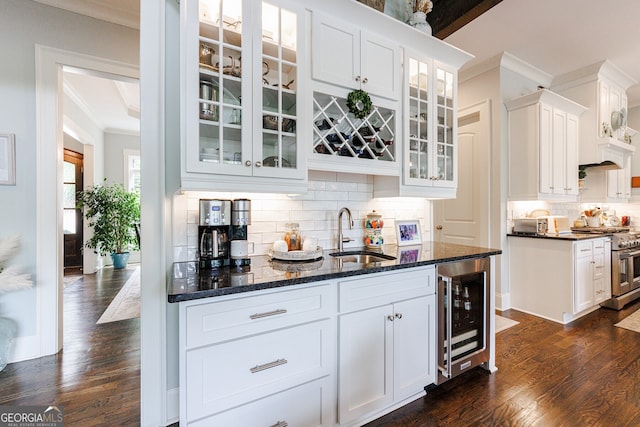 bar with wine cooler, decorative backsplash, sink, high end stainless steel range oven, and white cabinets