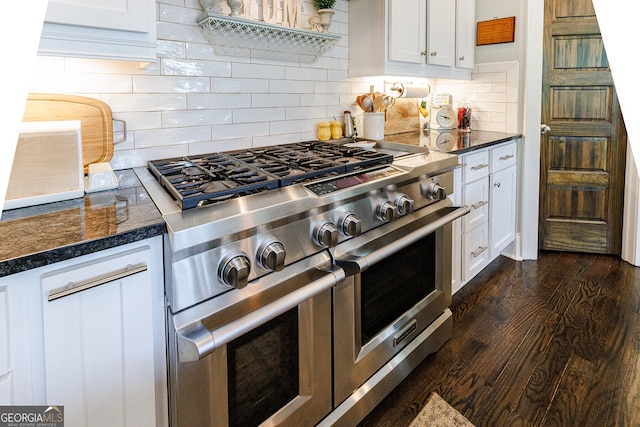 kitchen featuring tasteful backsplash, white cabinets, dark hardwood / wood-style floors, and range with two ovens