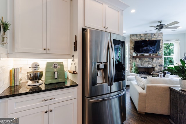 kitchen with a fireplace, stainless steel refrigerator with ice dispenser, decorative backsplash, white cabinets, and dark hardwood / wood-style flooring