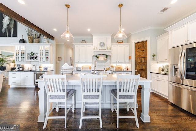 kitchen featuring decorative light fixtures, white cabinets, backsplash, and stainless steel fridge