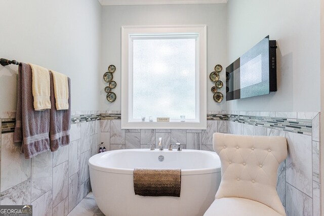 bathroom with a tub and tile walls