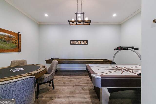 rec room with hardwood / wood-style floors, crown molding, and an inviting chandelier