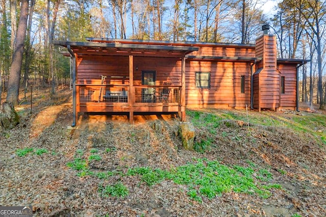 rear view of property featuring a wooden deck