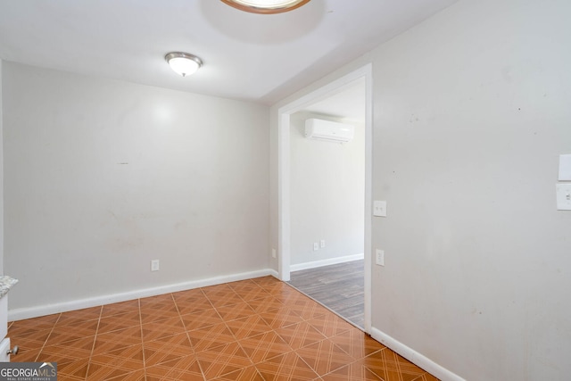 unfurnished room featuring a wall unit AC and baseboards