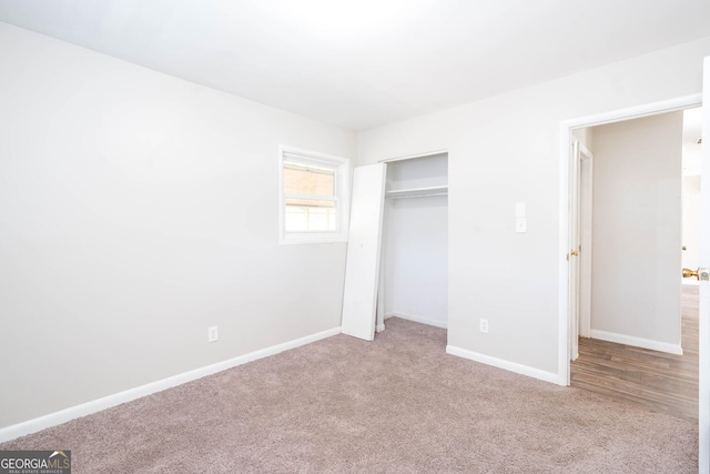 unfurnished bedroom featuring carpet floors, baseboards, and a closet