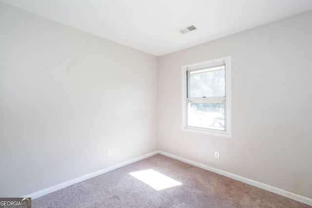 carpeted empty room featuring visible vents and baseboards