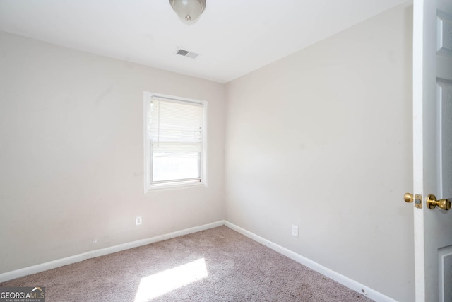 carpeted spare room featuring visible vents and baseboards