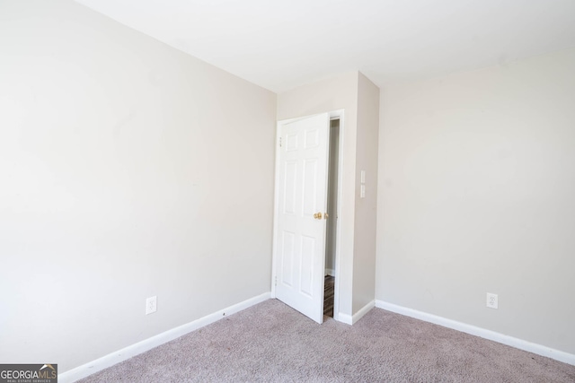 unfurnished bedroom featuring baseboards and light colored carpet