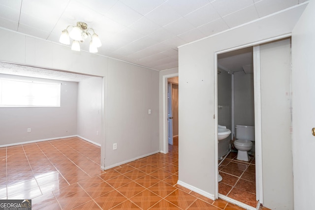 empty room featuring baseboards and tile patterned floors