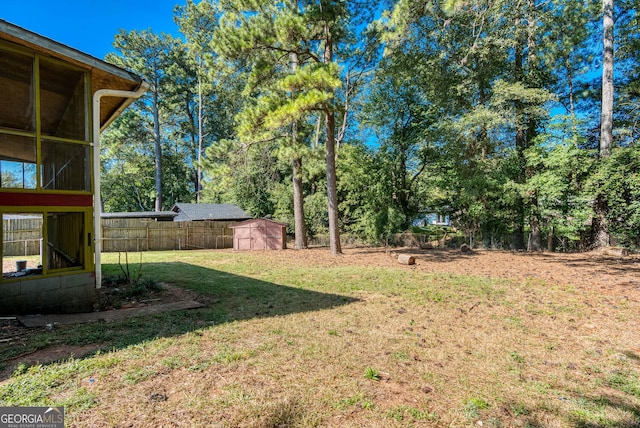 view of yard featuring a storage unit, fence, and an outbuilding