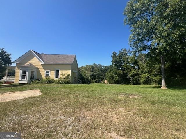 bungalow-style home with a front yard and covered porch