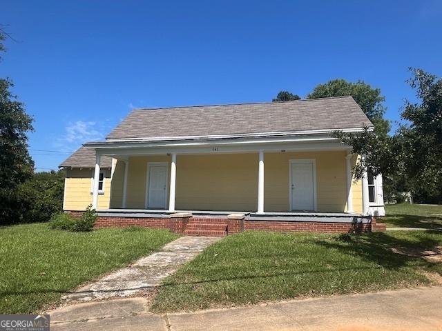 rear view of property with a lawn