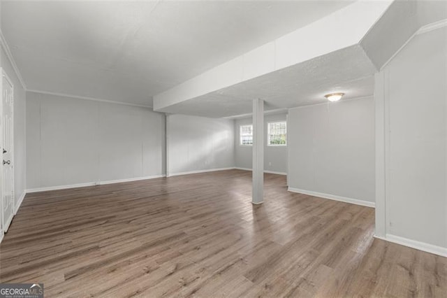 basement featuring baseboards and wood finished floors