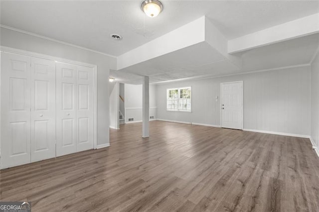 basement featuring stairway, wood finished floors, visible vents, and baseboards