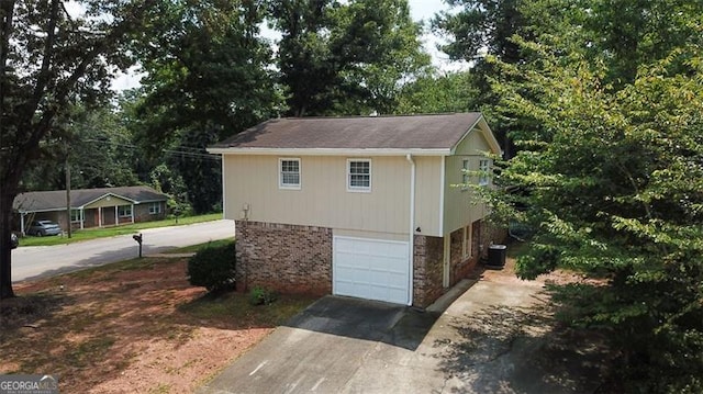 view of outdoor structure with driveway, an attached garage, and central AC