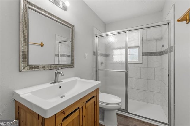 full bath featuring vanity, toilet, and a shower stall