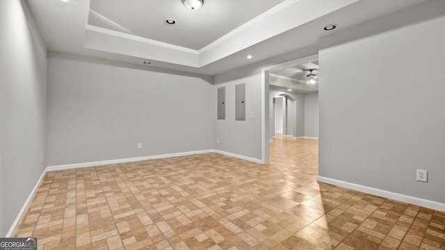 unfurnished room with a raised ceiling, electric panel, crown molding, and ceiling fan