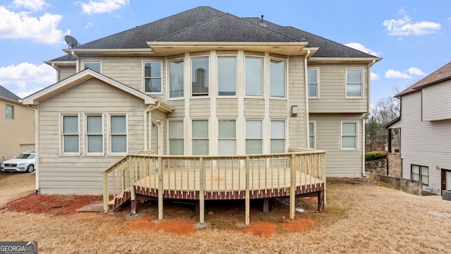 rear view of property featuring a wooden deck