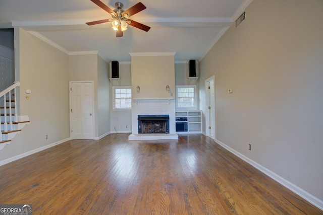 unfurnished living room with wood-type flooring, ornamental molding, ceiling fan, and a fireplace