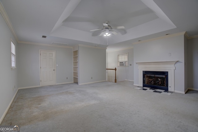 unfurnished living room with a tray ceiling, ornamental molding, light colored carpet, and ceiling fan