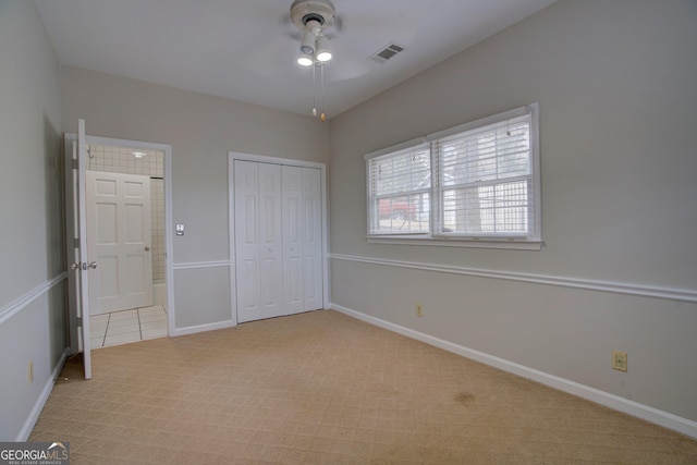 unfurnished bedroom with ceiling fan, light colored carpet, and a closet