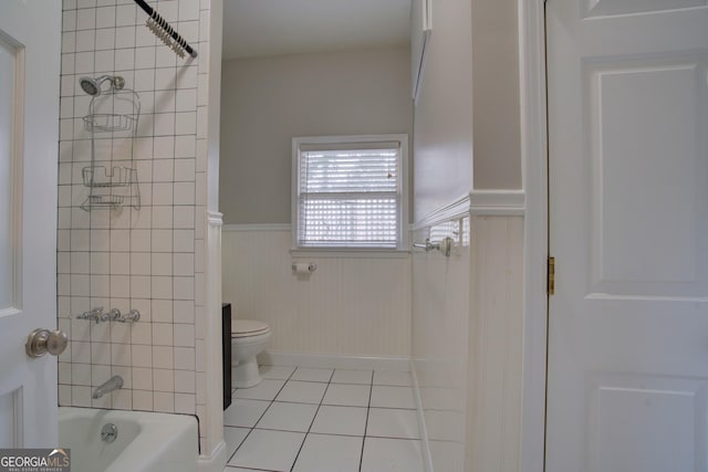 bathroom with tile patterned floors, toilet, and tiled shower / bath