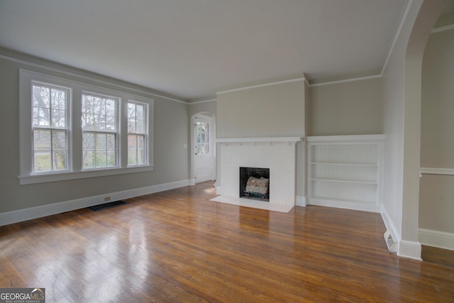 unfurnished living room with crown molding, dark hardwood / wood-style floors, and a fireplace