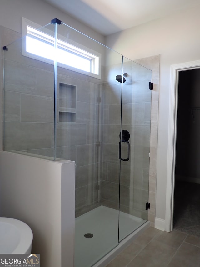 bathroom with tile patterned flooring and a shower with door