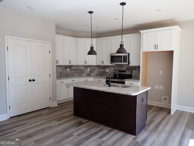 kitchen with appliances with stainless steel finishes, decorative light fixtures, sink, and wood-type flooring