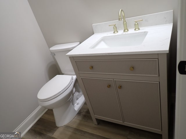 bathroom featuring toilet, hardwood / wood-style floors, and vanity