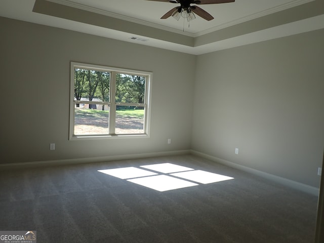 spare room featuring ceiling fan, carpet floors, a tray ceiling, and ornamental molding