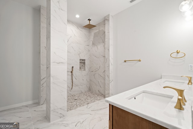 bathroom with vanity, a tile shower, and tile patterned flooring