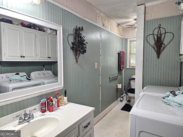 bathroom with ceiling fan, washing machine and clothes dryer, concrete flooring, toilet, and vanity