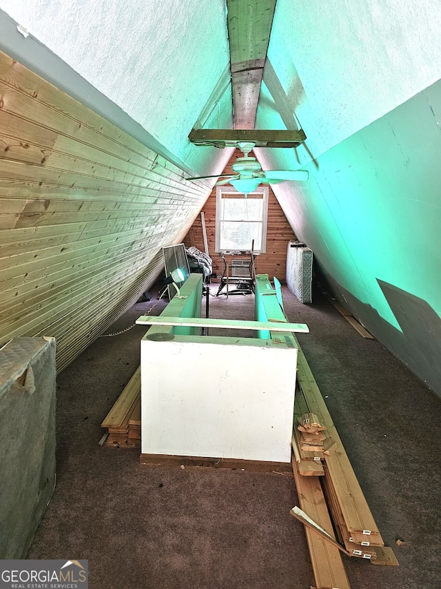 bonus room featuring carpet flooring, a textured ceiling, wooden walls, and lofted ceiling