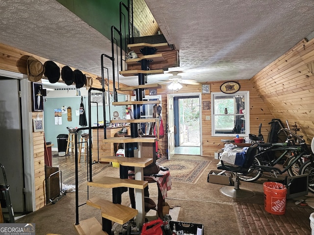 interior space with wooden walls and ceiling fan