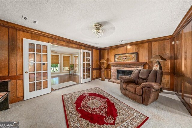 living room featuring ornamental molding, wooden walls, french doors, and light colored carpet