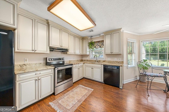 kitchen with visible vents, black appliances, cream cabinetry, and under cabinet range hood