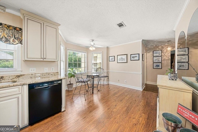 kitchen featuring cream cabinetry, light wood-type flooring, visible vents, ornamental molding, and dishwasher
