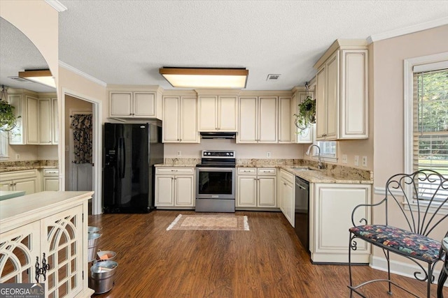 kitchen featuring cream cabinets, black appliances, a textured ceiling, and under cabinet range hood