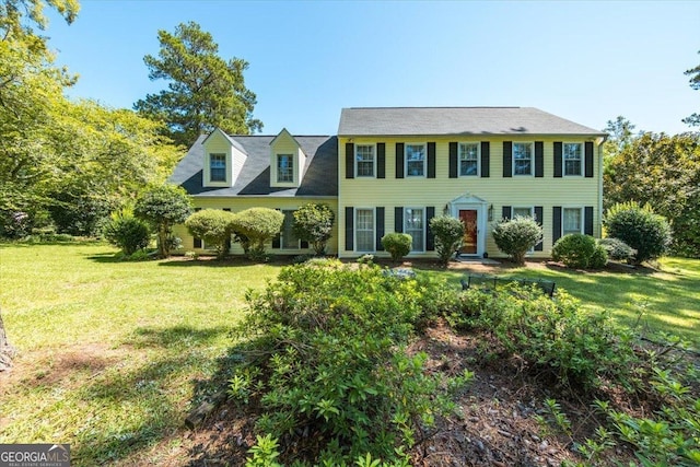 colonial-style house featuring a front lawn