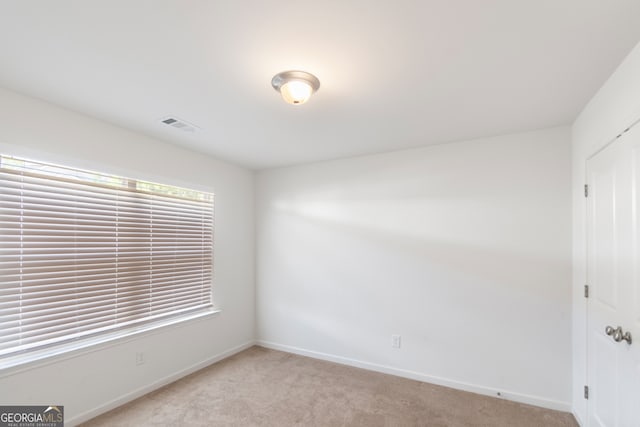 spare room featuring light carpet