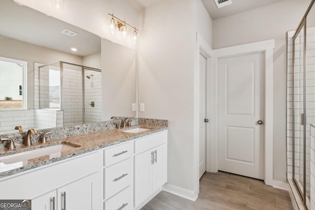 bathroom featuring vanity and a shower with door