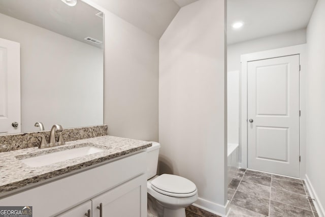 bathroom with a bath, vanity, and toilet