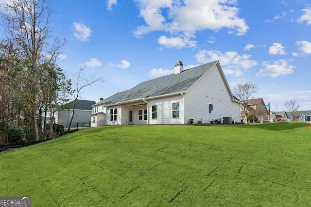 rear view of property featuring central AC unit and a lawn