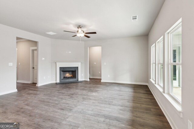 unfurnished living room with ceiling fan and dark hardwood / wood-style flooring