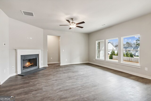 unfurnished living room featuring ceiling fan and dark wood-type flooring