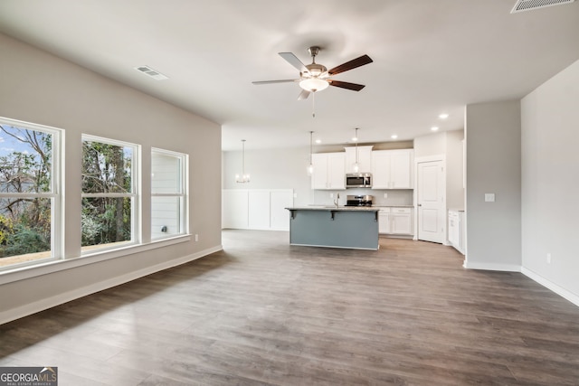 unfurnished living room with ceiling fan and hardwood / wood-style floors