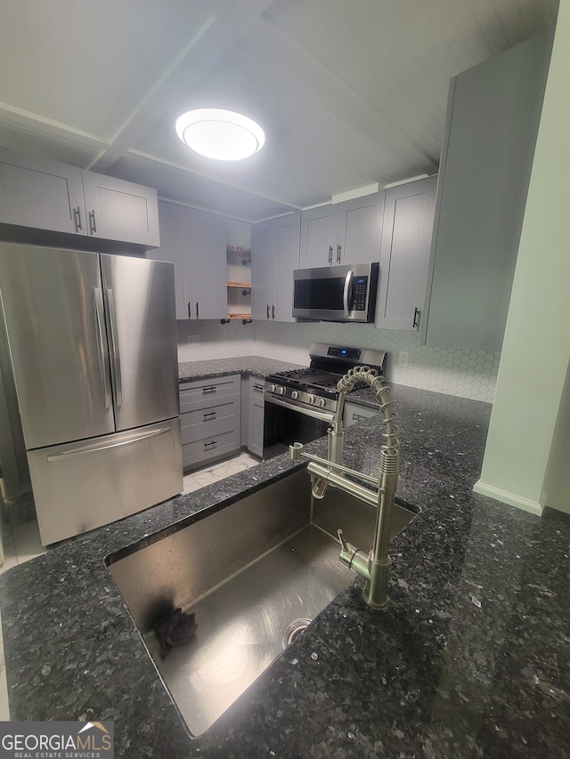 kitchen featuring dark stone counters, white cabinetry, and appliances with stainless steel finishes